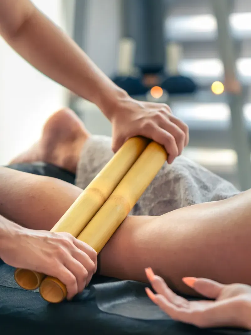 Bambuterapia sendo aplicada nas coxas para contorno e modelagem em Curitiba.
